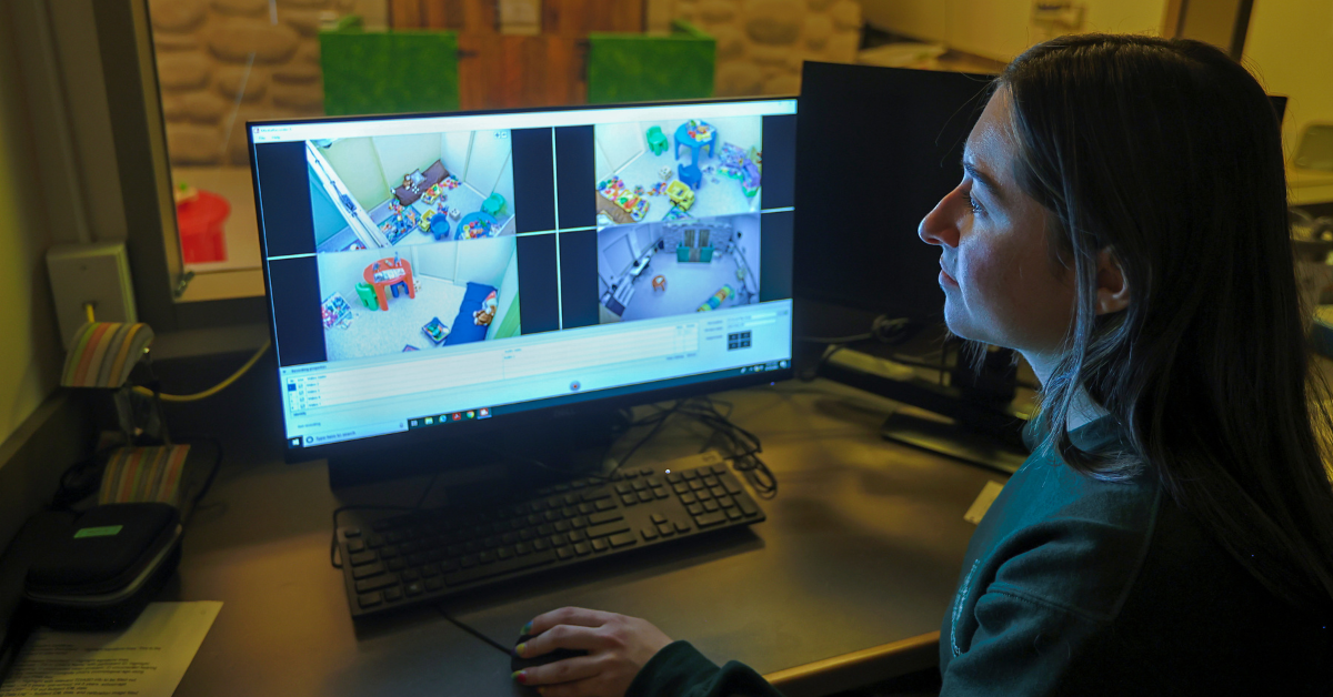 A student looking at a monitor with the play castle in the background.